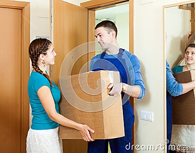 Happy mailman in uniform brought package to girl at home