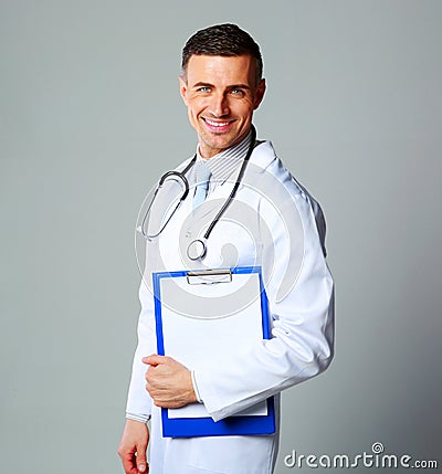 Happy male doctor holding empty clipboard