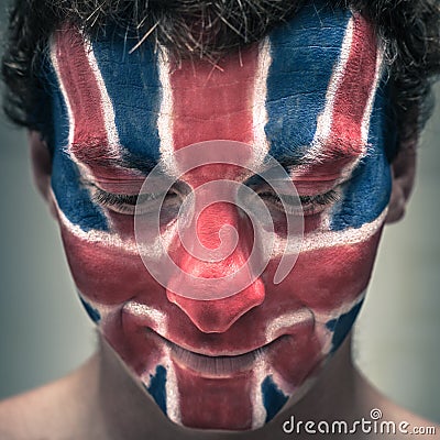 Happy man with British flag on face looking down