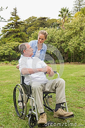 Happy man in wheelchair and daughter talking