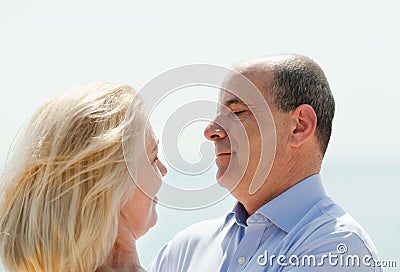 Happy mature couple with sea beach in background