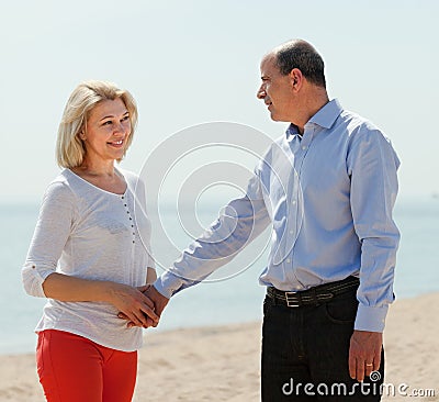 Happy mature woman with man against sea