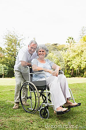 Happy mature woman in wheelchair with partner