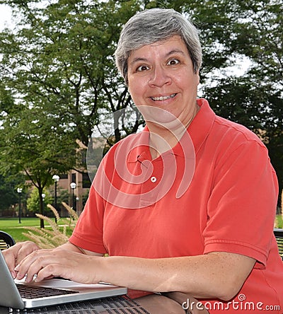 Happy middle-aged woman at laptop