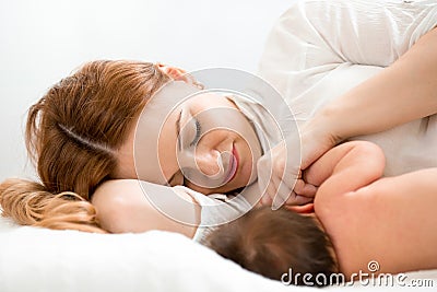Happy mom breastfeeding newborn baby