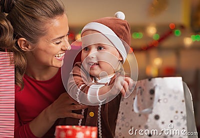 Happy mother and baby checking christmas shopping bags