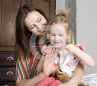 Happy mother and daughter in bed, smiling hugging