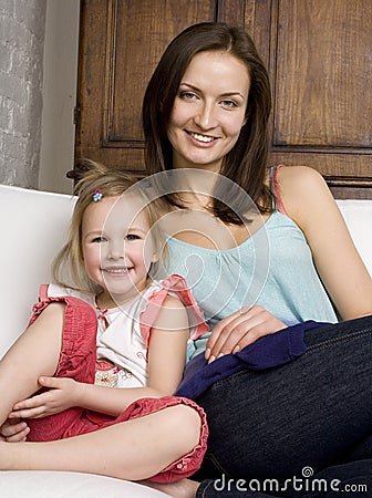 Happy mother and daughter in bed, smiling hugging