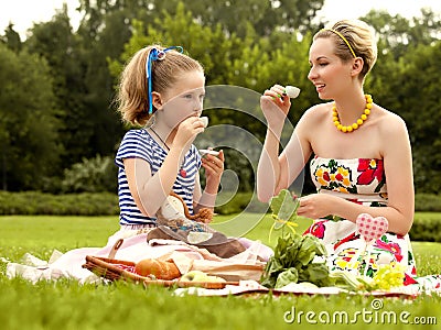 Happy mother and daughter drinking Coffee. Family picnic