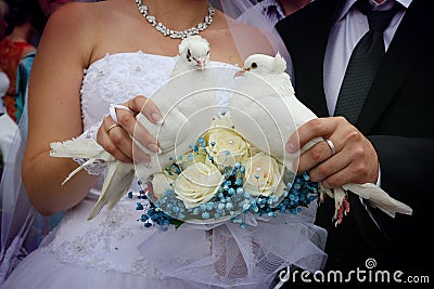 Happy newlyweds holding white doves