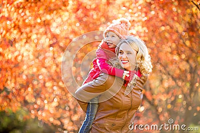 Happy parent and kid family walking together outdoor in fall