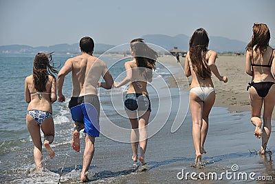 Happy people group have fun and running on beach