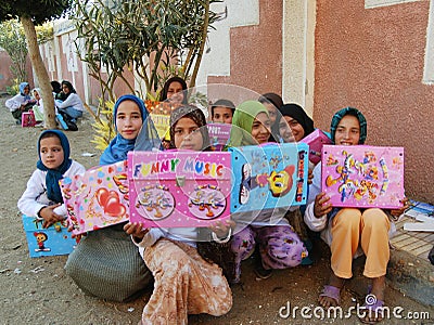 Happy poor muslim girls in veil received presents and gifts in Egypt