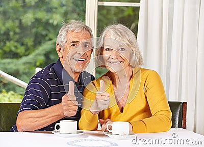 Happy senior couple holding thumbs
