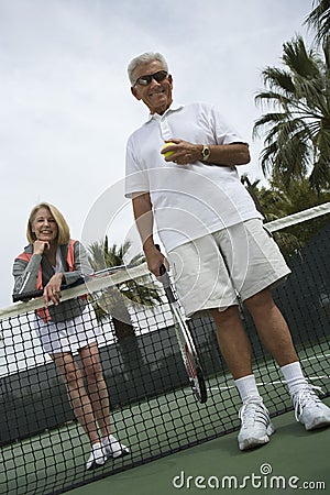 Happy Senior Couple Playing Tennis