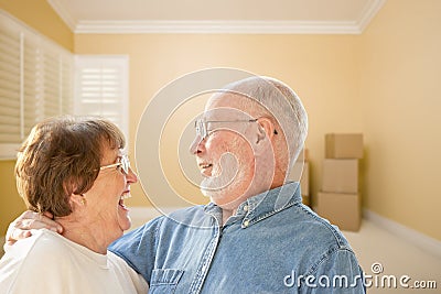 Happy Senior Couple In Room with Moving Boxes on Floor