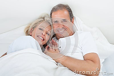Happy senior couple on sleeping bed