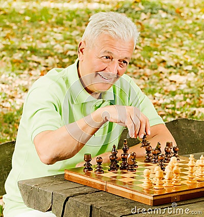 Happy senior man playing chess