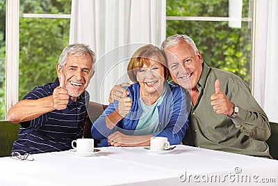 Happy senior people holding thumbs