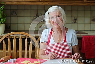Happy senior woman baking cookies in the kitchen