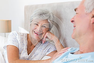Happy senior woman with man in bed