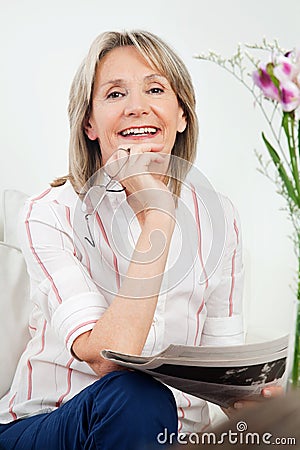 Happy senior woman with newspaper