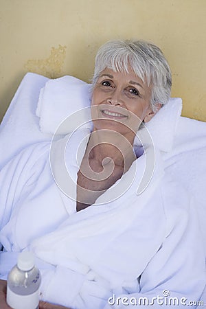 Happy Senior Woman Relaxing On Lounge Chair