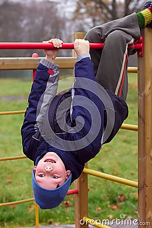 Happy smiling child in playground head down