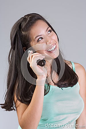 Happy smiling Latina woman talking on cell-phone