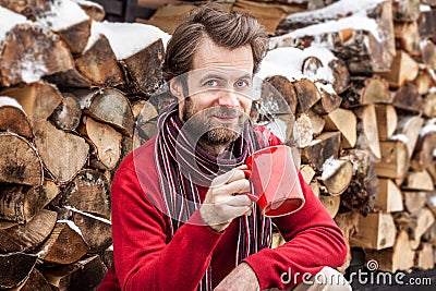 Happy smiling man drinking hot tea outdoor - winter countryside landscape