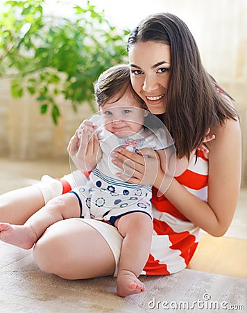 Happy smiling mother with eight month old baby girl