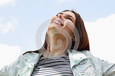 Happy smiling young attractive woman over blue sky