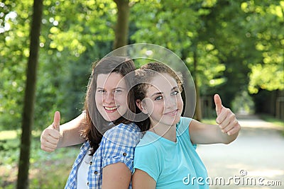 Happy teenage girls giving a thumbs up