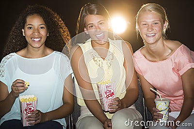 Happy Teenage Girls Watching Movie In Theater