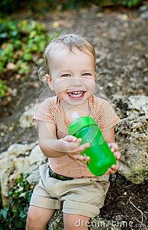 Happy toddler boy drinks water