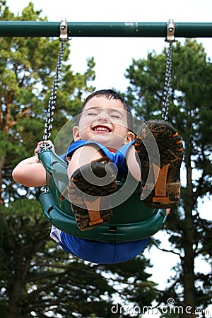 Happy Toddler Boy Laughing On Swing