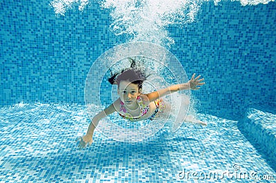 Happy underwater child jumps to swimming pool