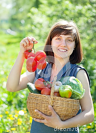 Happy woman with basket of harvested vegetables