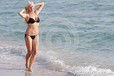 Happy woman in black bikini on sea background