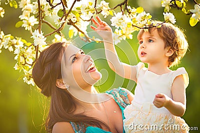 Happy woman and child in the blooming spring garden.Child kissi