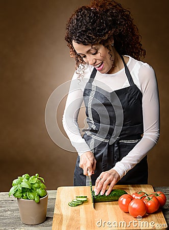 Happy Woman Cooking. Healthy Food - Fresh cucumber