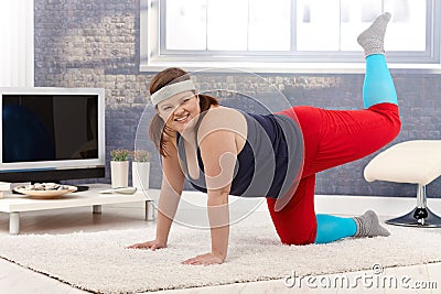Happy woman doing gymnastics at home