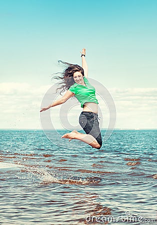 Happy woman jumping in the water of sea