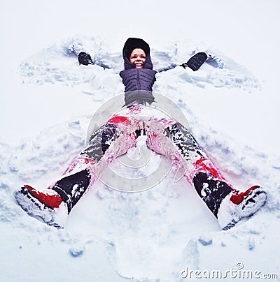 Happy woman making snow angel