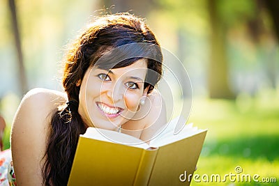 Happy woman reading book in park