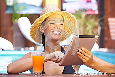 Happy woman with tablet computer in pool