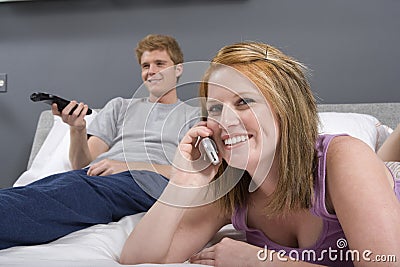 Happy Woman Using Cell Phone In Bedroom