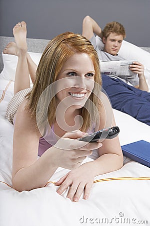 Happy Woman Watching TV In Bed