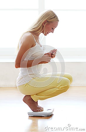 Happy woman with weight scales