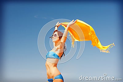 Happy woman with yellow sarong on the beach